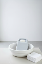 Washboard resting on basin edge with soap